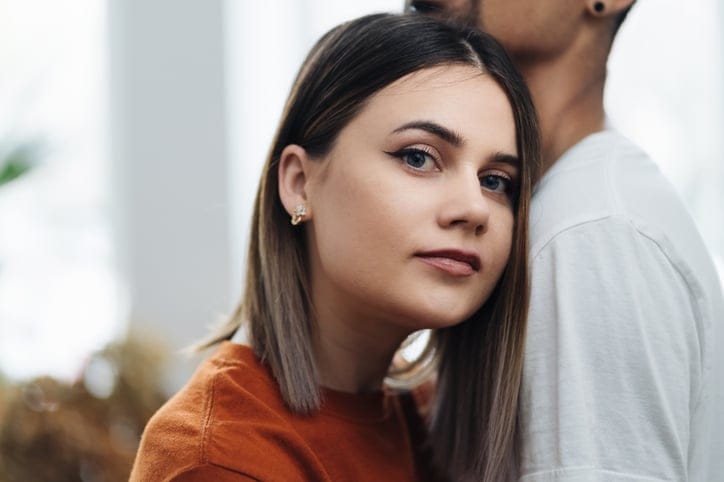 serious woman leaning on boyfriend's chest