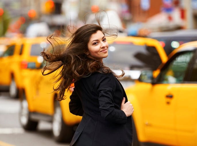 Woman in Union Square in New York with yellow taxi cabs.