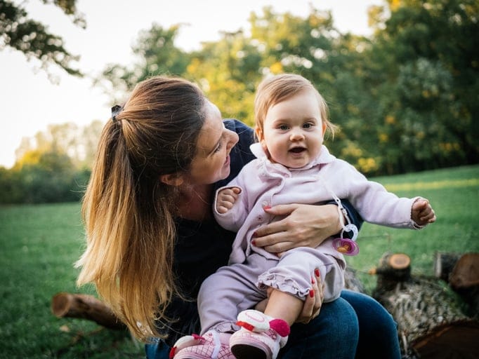 Mom and her baby outside on a picnic.