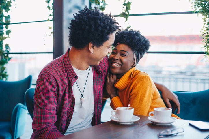 Happy couple embracing in a coffee shop.