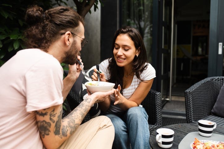 young couple eating takeout outside