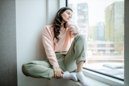 sad woman sitting on a window