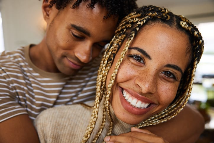 Affectionate young couple smiling while together at home.