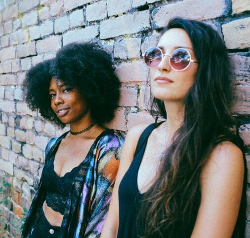 black woman and white woman against wall