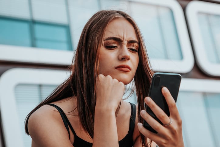 annoyed woman looking at phone