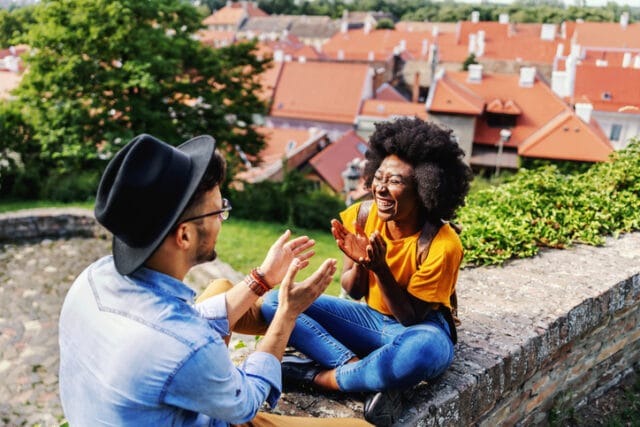 happy couple sitting on outdoor ledge