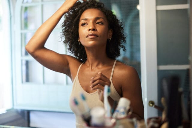 Black woman looking in mirror