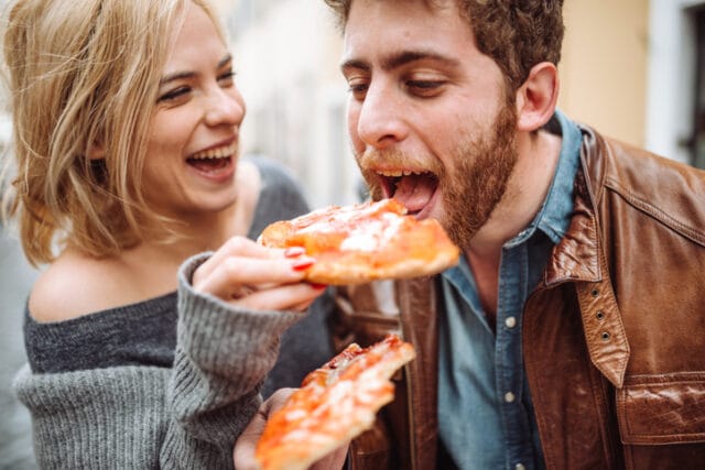 Couple sharing pizza in Italy.
