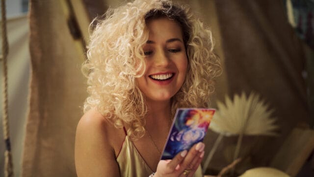 Woman smiling at tarot cards.