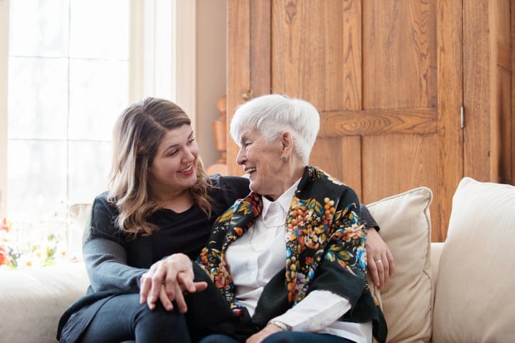 woman sitting with grandmother on couch