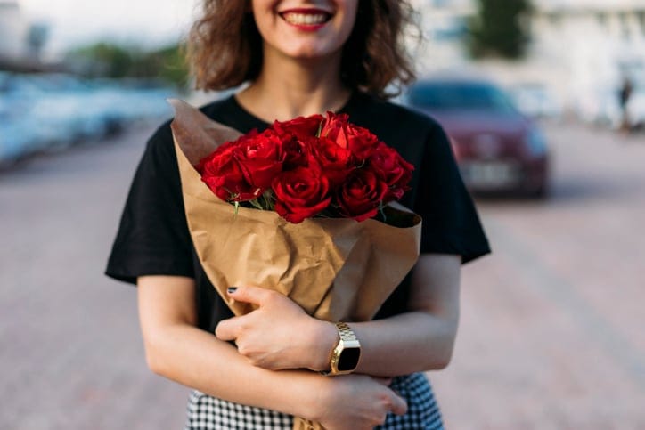 Smiling woman with bouquet of flowers.