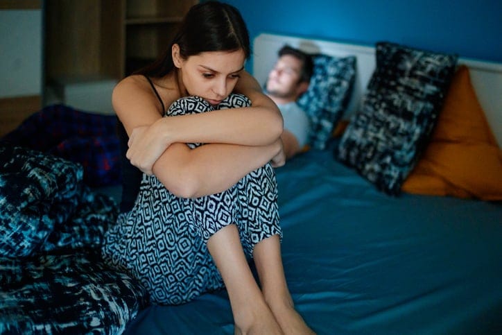 Upset woman awake in bed.