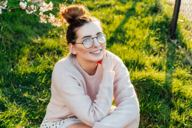smiling woman sitting in grass