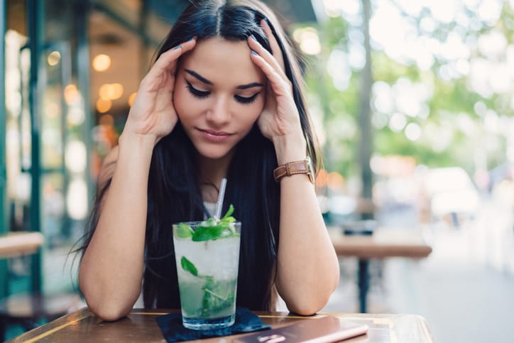 Woman alone at bar disappointed.