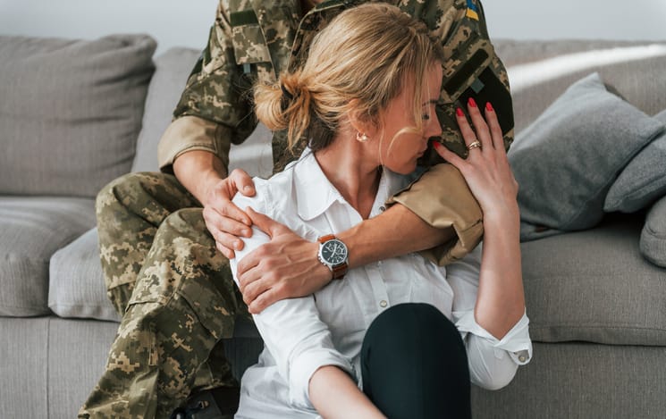 upset woman hugging military boyfriend