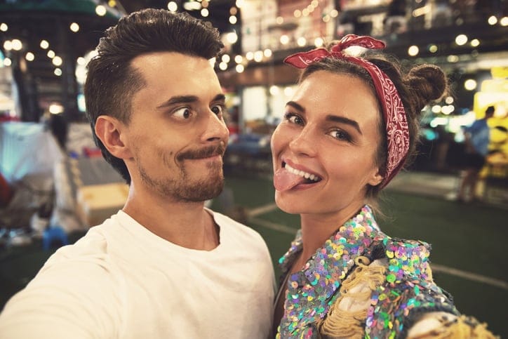 Couple making funny faces at a street fair.