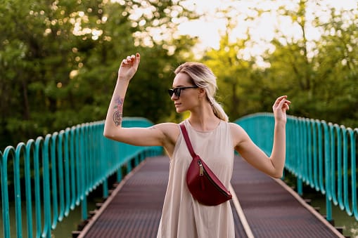 Carefree woman in a dress walking on the bridge.