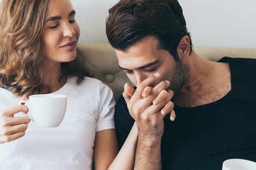 Man kissing woman's hand.