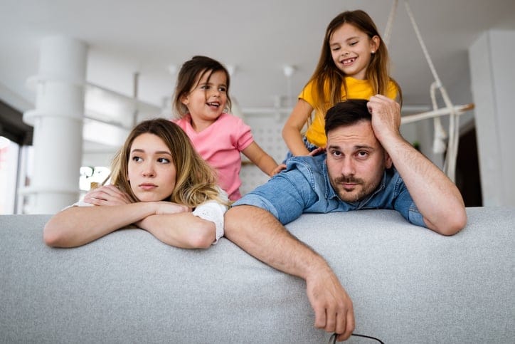 Tired mother and father annoyed with noisy children.