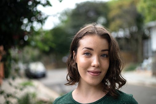 single woman smiling outside