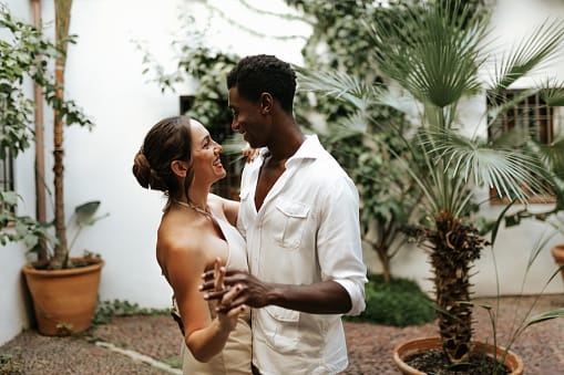 Happy young couple dancing together in their backyard.