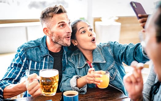 Smiling couple taking selfie at brewery.