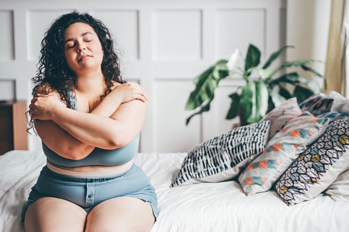 Woman getting dressed in her bedroom.