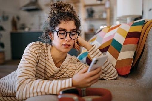 young woman texting on the couch