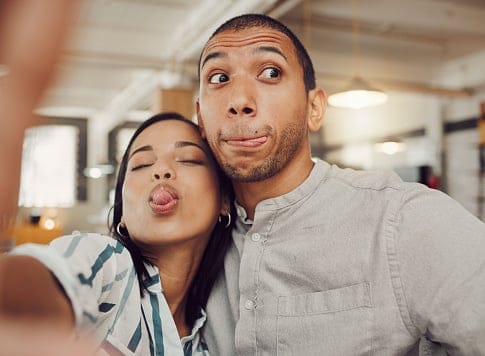 Funny young woman taking a selfie with her boyfriend.