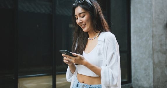 smiling woman texting in city
