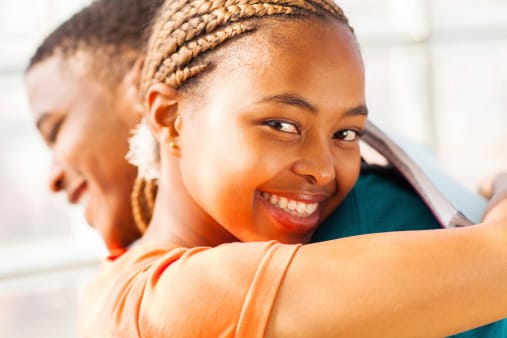 beautiful young african girl hugging her boyfriend