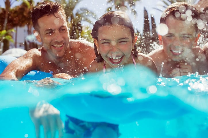 dad swimming on vacation with kids