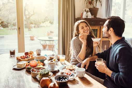 Couple sitting at a table and having breakfast together.