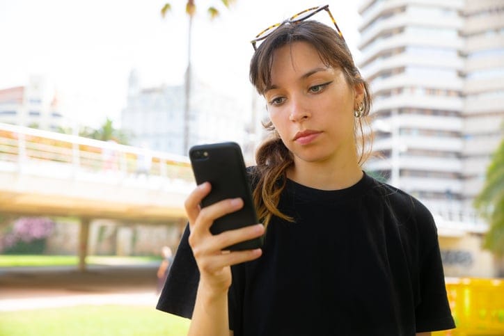 Woman seriously texting outside.