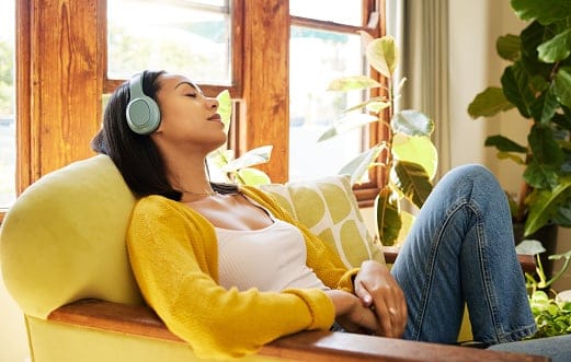 Woman alone listening to music on headphones.