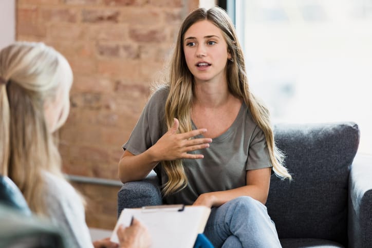 Female client gestures while talking to therapist