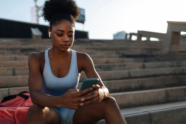Woman texting at the track.