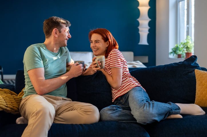 smiling couple chatting on sofa