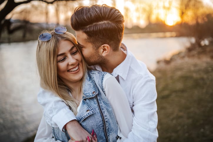 Happy young couple embracing by the river