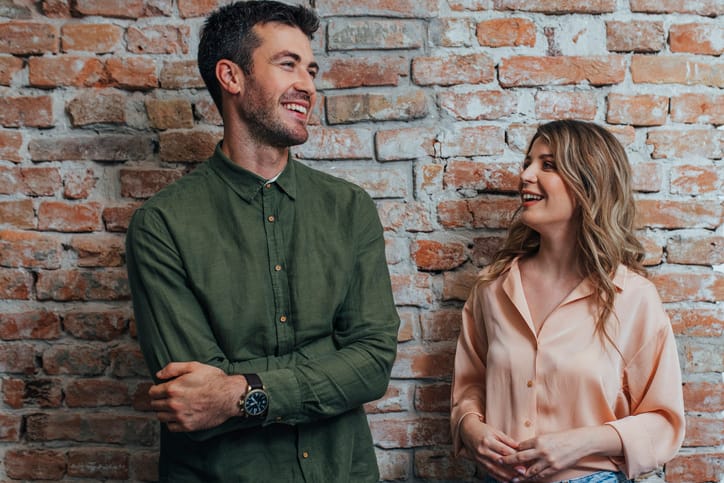 Young Man and Woman Smiling and Chatting at the Office