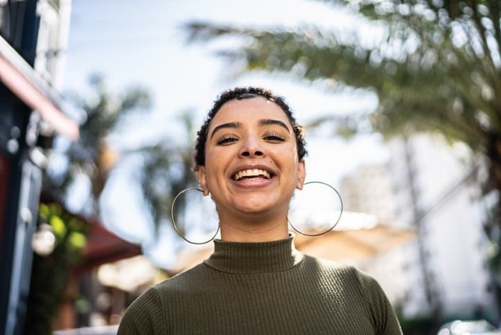 confident millennial woman smiling outside