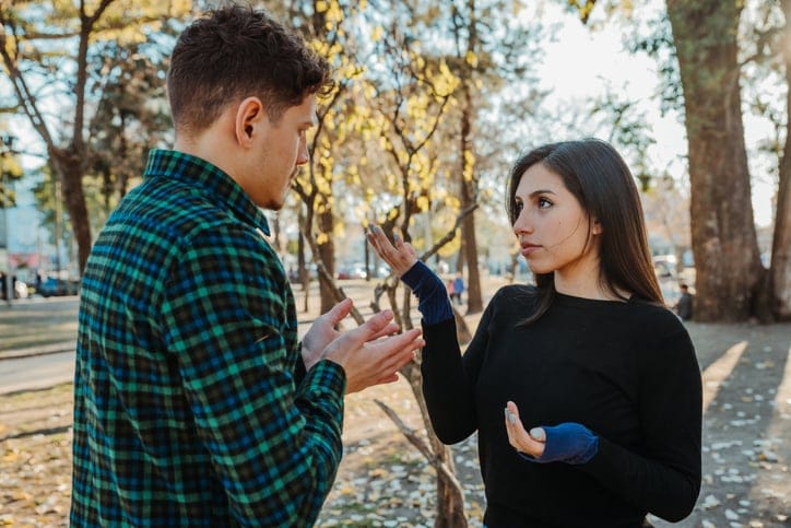 male female friend in argument at park