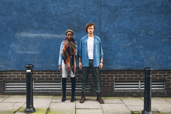 Couple posing for a portrait against a blue wall