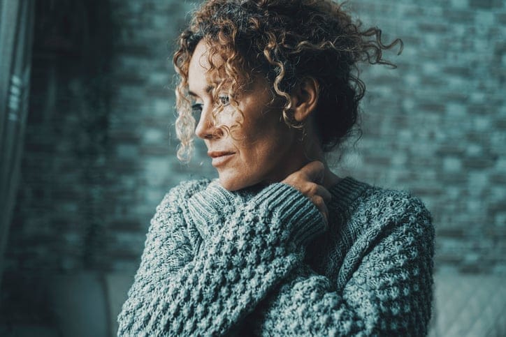 Woman with her hands on her neck.