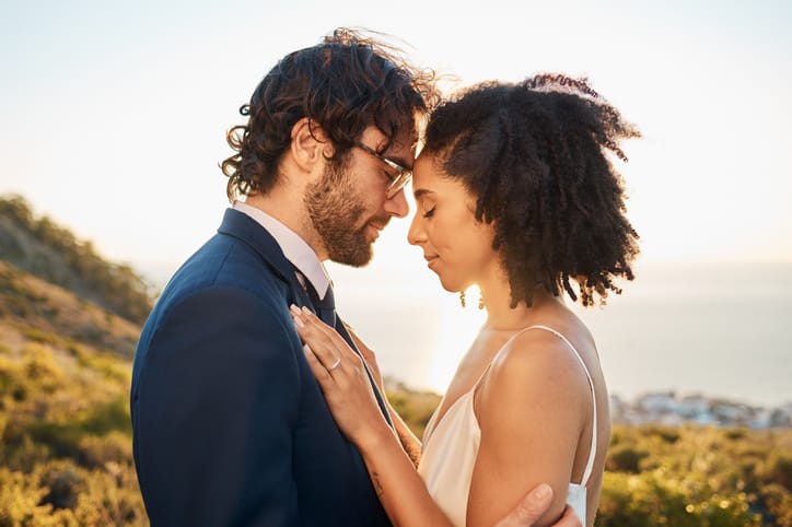 Wedding, interracial couple love and worship of people outdoor for marriage and save the date. Prayer, celebration and bride with man for commitment, care and pray together feeling calm in nature