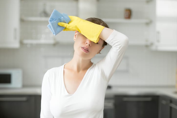 A woman feels tired out from house cleaning.