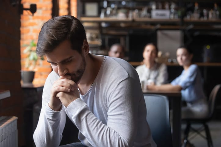 Sad man sitting alone in a cafe.