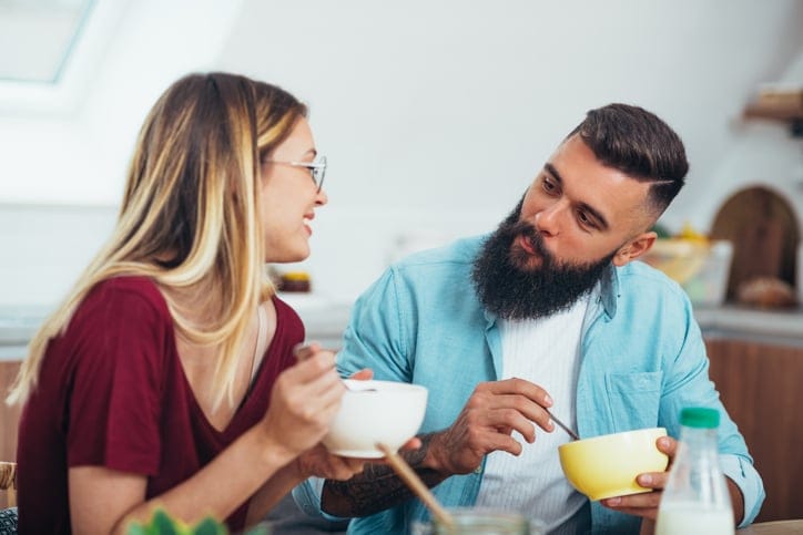 Young couple eating breakfast together at home.