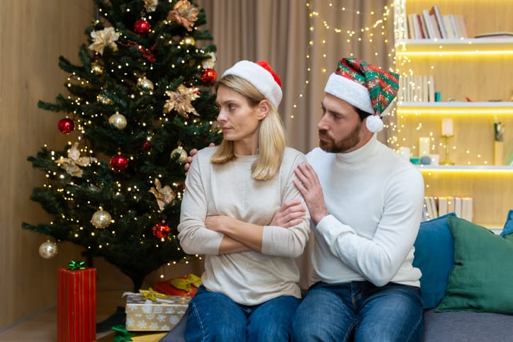 man touching upset girlfriend on christmas