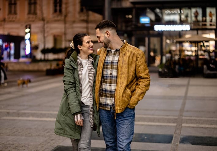 A couple takes a quiet walk at night, hugging each other and enjoying each other's company in a loving embrace